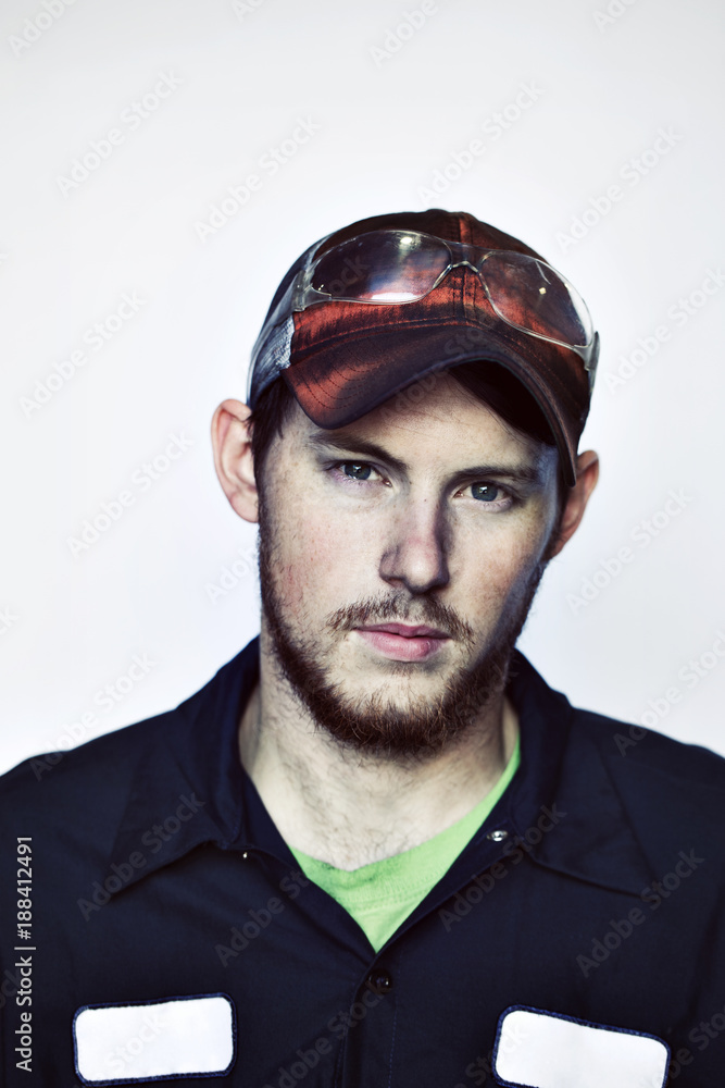 Portrait of young worker wearing cap against white background Portrait of young worker wearing cap against white background