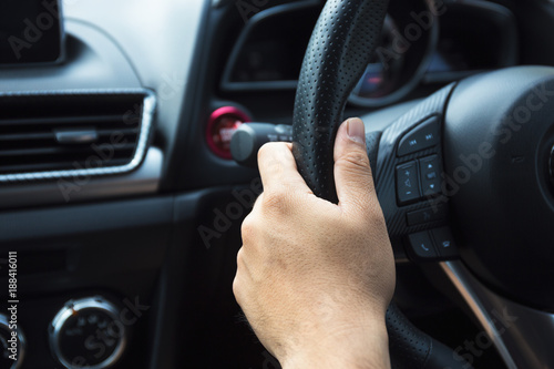 male Driver's hands on a steering wheel of a modern car during riding, close up