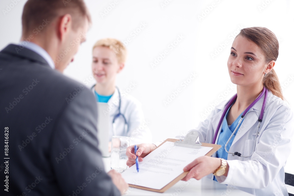Women doctor and patient sitting at the desk in hospital. Women doctor Women doctor and patient sitting at the desk in hospital. Women doctor