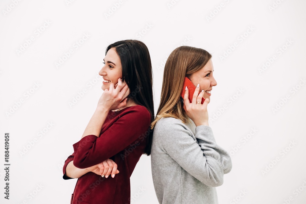 Girl talking on the phone on white background leaning backs Girl talking on the phone on white background leaning backs