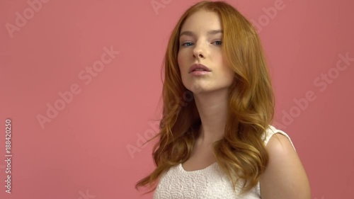 Wallpaper Mural Beautiful teenage girl with red blowing hair and blue eyes on pink background Torontodigital.ca