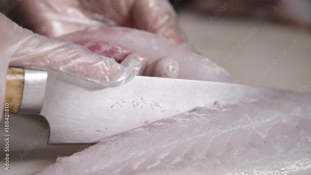 Slow motion, chef uses knife on fish meat Slow motion, chef uses knife on fish meat