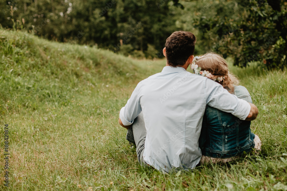 Couple in love is sitting on the grass and having romantic evening. Love concept Couple in love is sitting on the grass and having romantic evening. Love concept