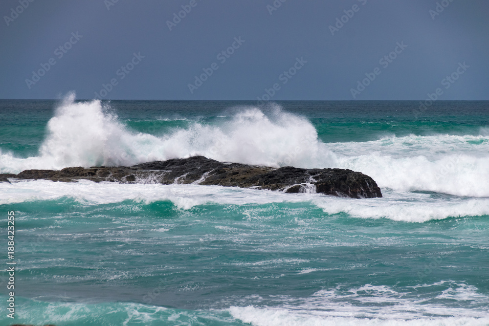 Waves crashing over rocks with sea spray