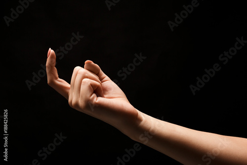 Fotografi Female hand beckoning isolated on black background