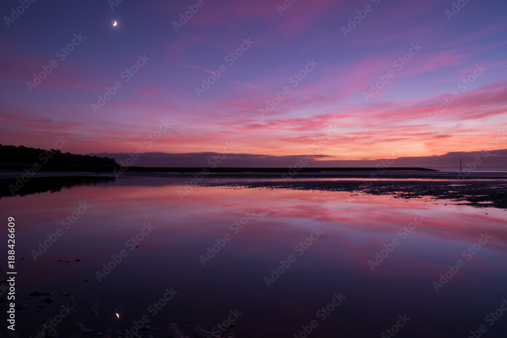 Purple sunset on the beach with wonderfull  reflection in water