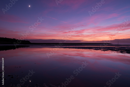 Purple sunset on the beach with wonderfull reflection in water