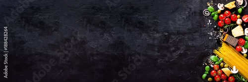 Obraz  z motywem Food ingredients for italian pasta, spaghetti on black stone slate background. Copy space of your text. Banner