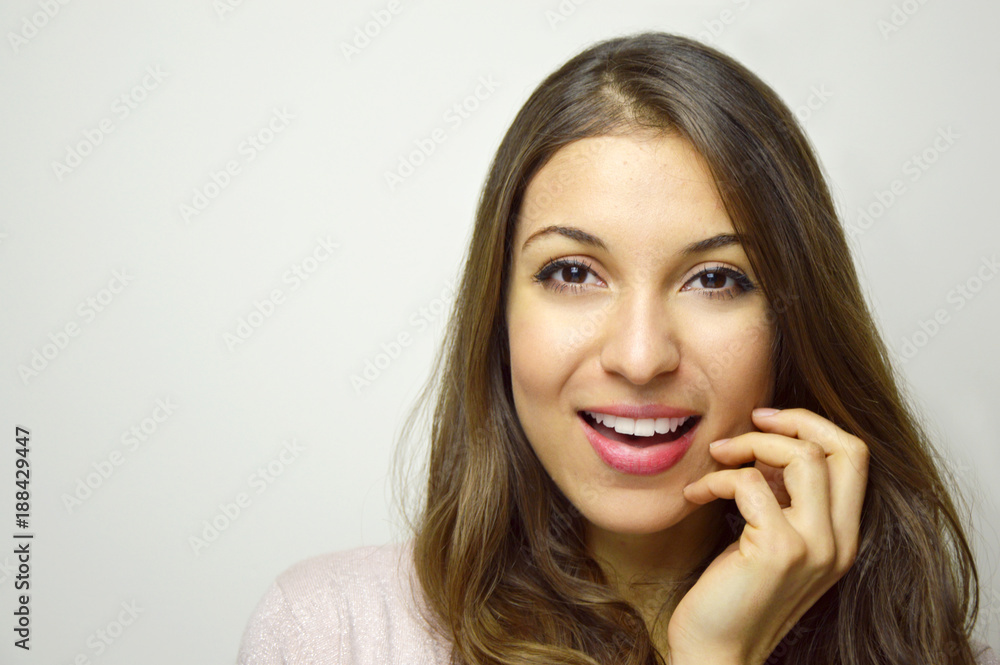 Beautiful young woman looking at camera with hand near face on white background. Copy space. Beautiful young woman looking at camera with hand near face on white background. Copy space.