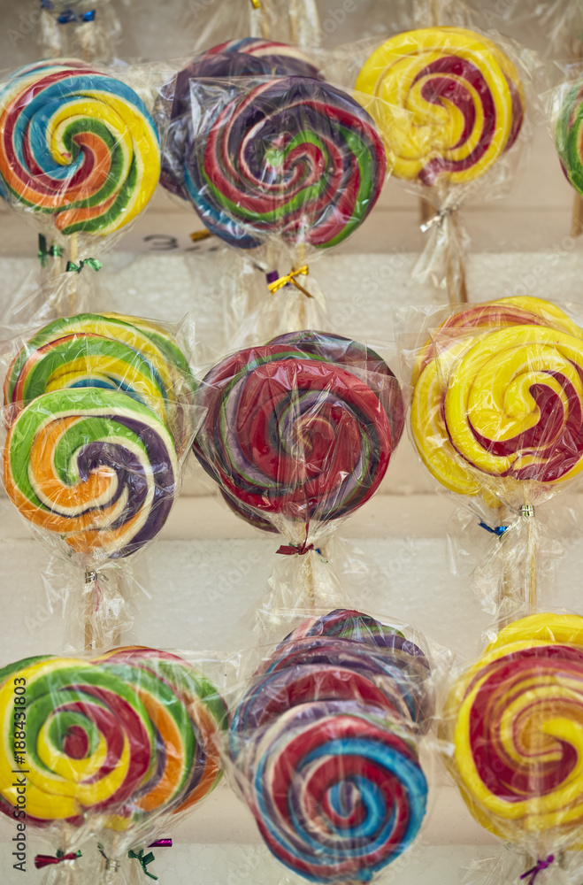 Colorful rainbow-swirl lollipops on display on the shelves in the market, Colorful rainbow-swirl lollipops on display on the shelves in the market,