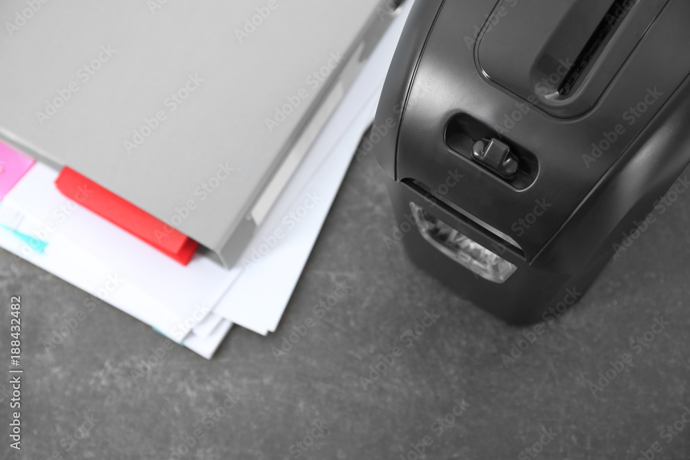 Document shredder and papers on table, closeup Document shredder and papers on table, closeup