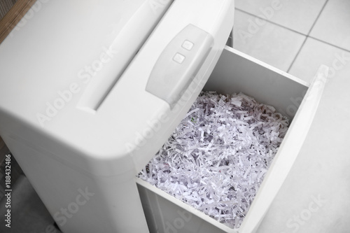 Document shredder with paper shreds indoors,closeup