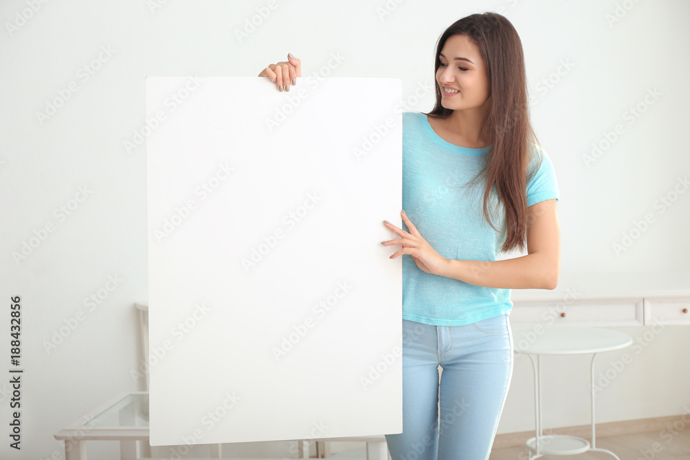 Young woman with blank advertising board indoors Young woman with blank advertising board indoors