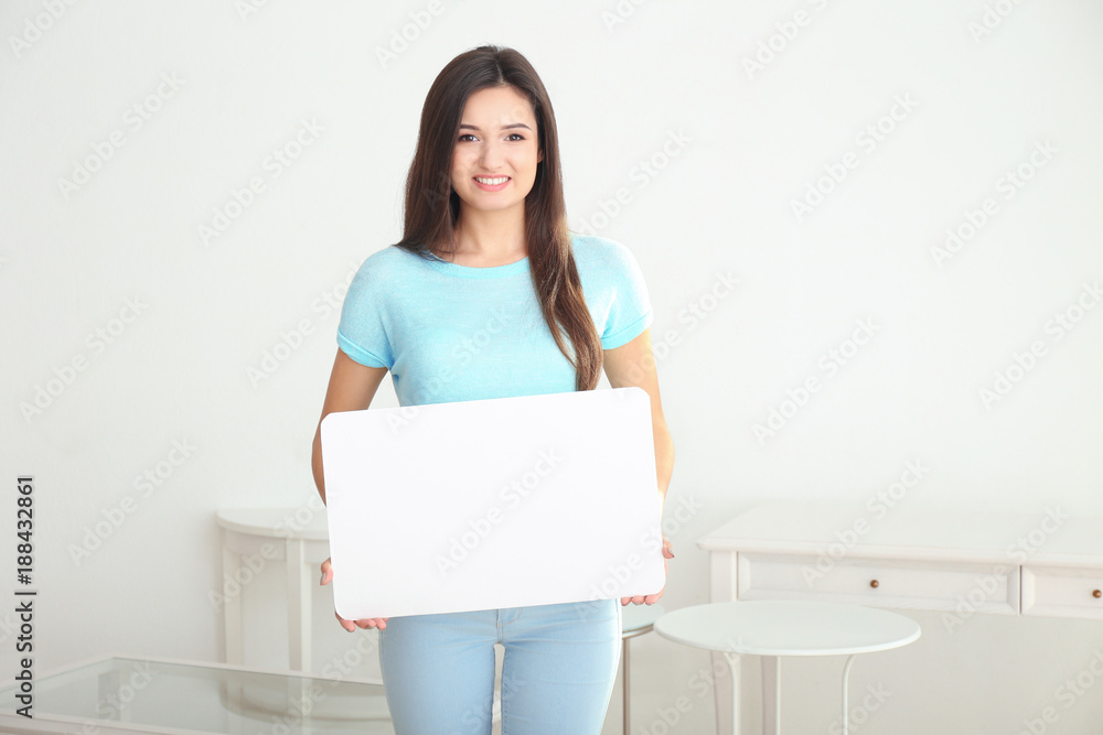 Young woman with blank advertising board indoors Young woman with blank advertising board indoors