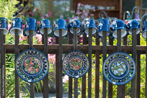 Traditional hand-made porcelain dishes hanged on  fence photo