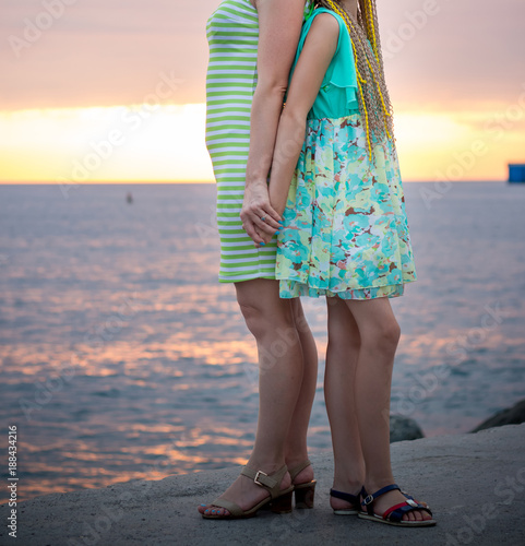 Mother and daughter are standing on the beach