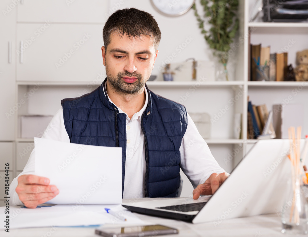 Fototapeta premium Businessman in shirt working with laptopt and documents