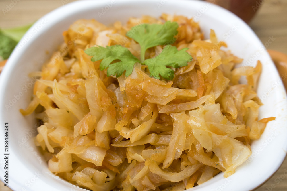Appetizing stewed cabbage close-up and a sheet of parsley. Appetizing stewed cabbage close-up and a sheet of parsley.