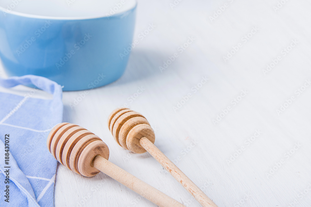 Blue Empty Bowl Wooden Honey Dippers Spoons Cotton Apron on White Table. Holiday Baking Cooking Concept. Christmas Easter. Kitchen Interior. Social Media Blog Recipe Template Blue Empty Bowl Wooden Honey Dippers Spoons Cotton Apron on White Table. Holiday Baking Cooking Concept. Christmas Easter. Kitchen Interior. Social Media Blog Recipe Template
