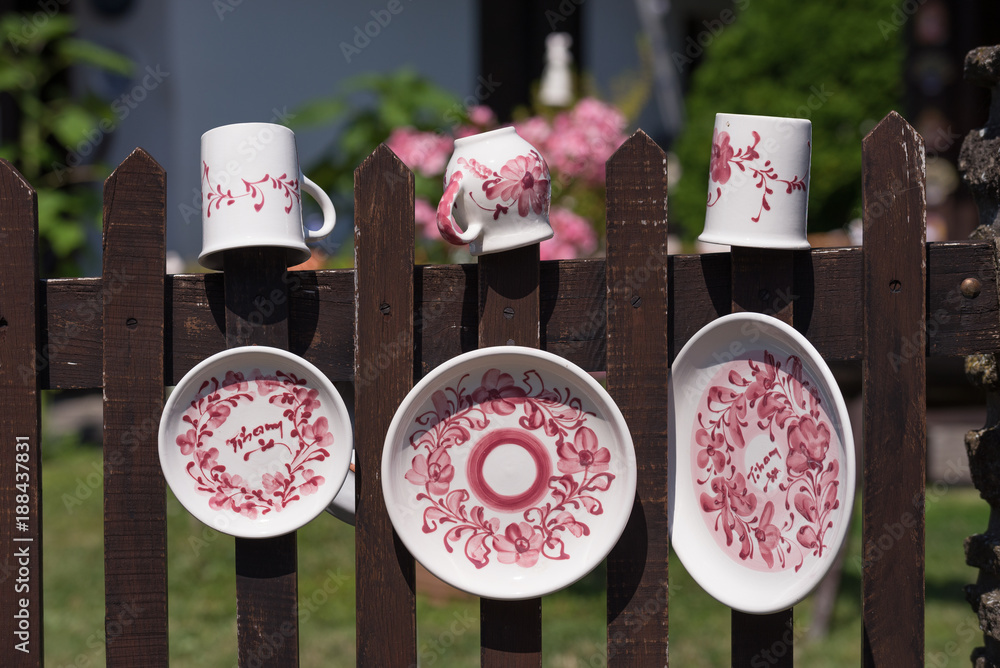 Colorful traditional hand-made porcelain dishes hanged on the fence