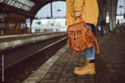 woman stand on the railway station hold backpack