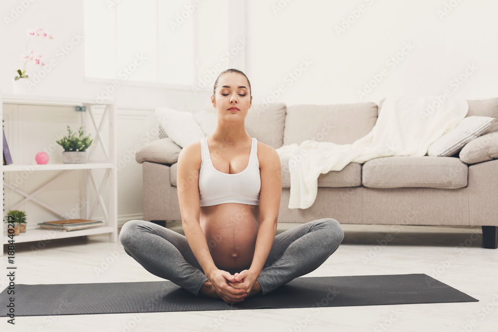 Happy pregnant woman training yoga in lotus pose Happy pregnant woman training yoga in lotus pose