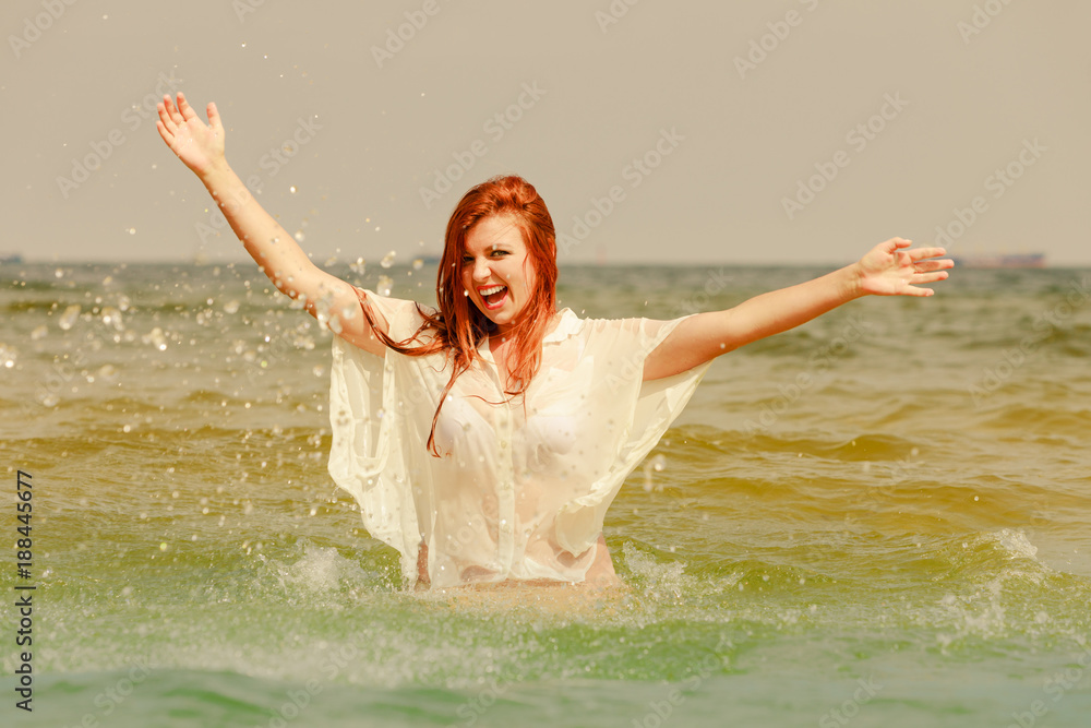 Redhead woman playing in water during summertime Redhead woman playing in water during summertime