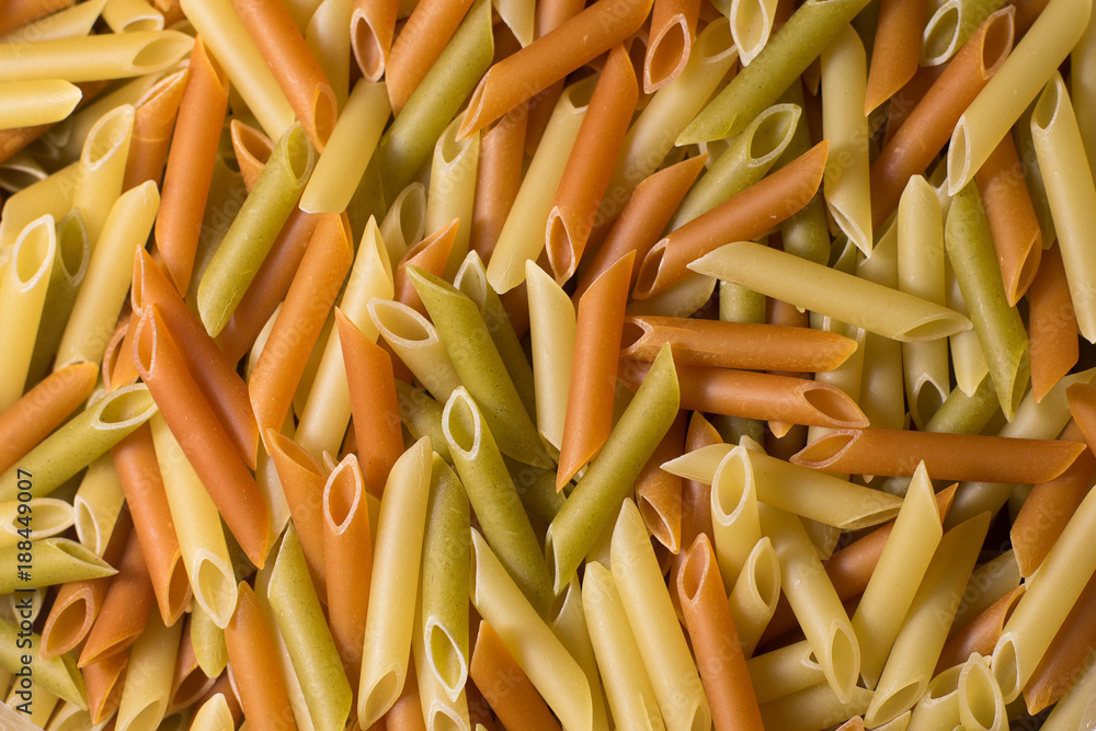 background of scattered, uncooked, colorful macaroni background of scattered, uncooked, colorful macaroni