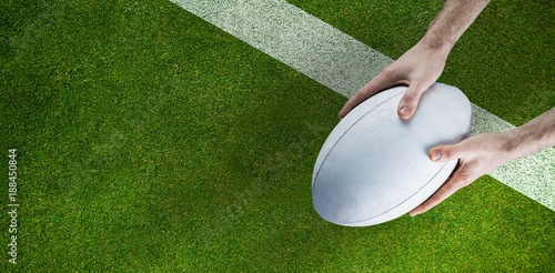 Composite image of a rugby player posing a rugby ball