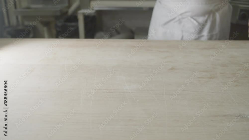 Slow motion, baker tosses flour on counter Slow motion, baker tosses flour on counter