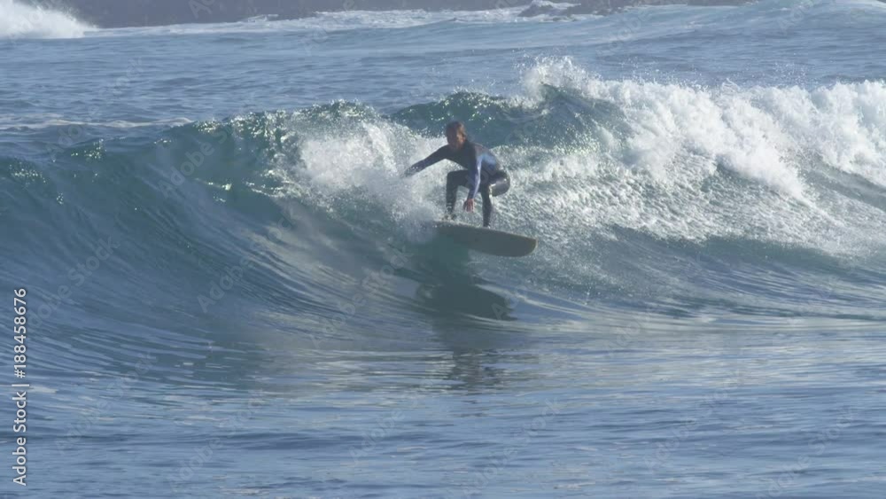 SLOW MOTION: Awesome slow motion of surfer getting swallowed by a crystal clear tubing ocean wave. Sportsman rides large barrel wave on cool surfboard. Deep blue sea water splashes on crouching surfer SLOW MOTION: Awesome slow motion of surfer getting swallowed by a crystal clear tubing ocean wave. Sportsman rides large barrel wave on cool surfboard. Deep blue sea water splashes on crouching surfer