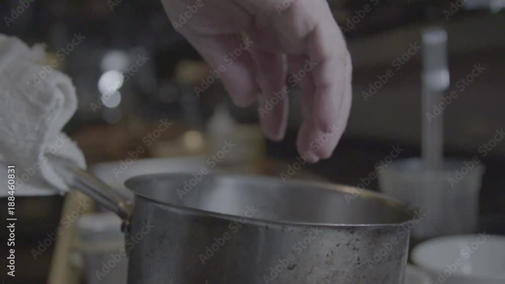 Chef throws squid pieces into pot, close up Chef throws squid pieces into pot, close up