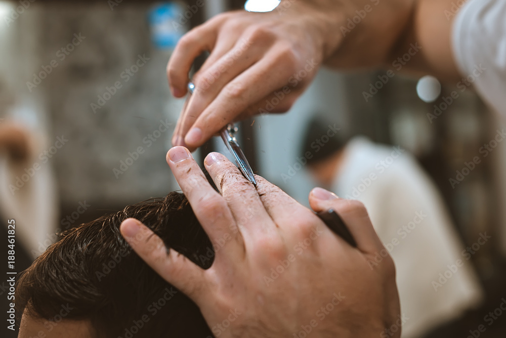 Fototapeta premium Closeup of smiling man getting an haircut from barber