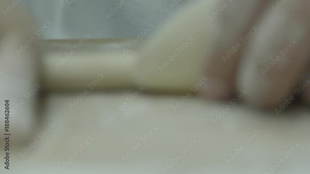Slow motion close up, chef rolls out dumpling dough Slow motion close up, chef rolls out dumpling dough