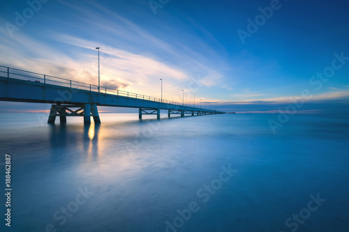 Industrial pier on the sea. Side view. Long exposure photography.