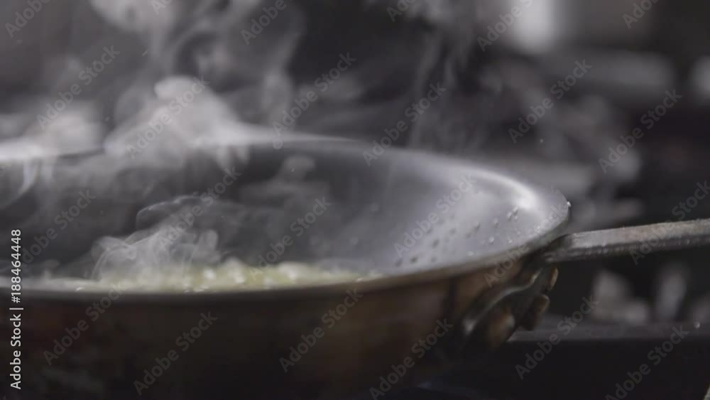 Slow motion, cooking onions on stove Slow motion, cooking onions on stove