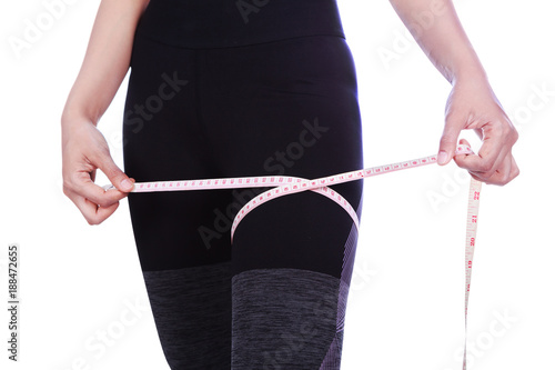 close up woman is measuring her thigh with measure tape isolated on white background