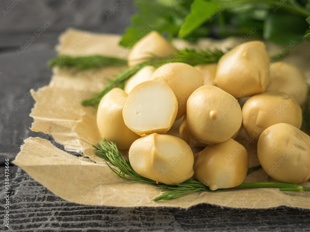 Herbs with balls of freshly made mozzarella cheese on a wooden table. Selective focus. Herbs with balls of freshly made mozzarella cheese on a wooden table. Selective focus.