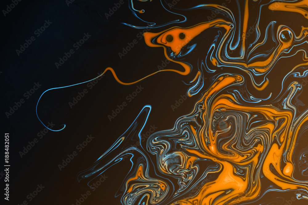 Swirling paint oil abstracts of water and acrylic paint creating a hazardous pollution theme for environment and nature themes and ideas. Globes release into the orange black liquid