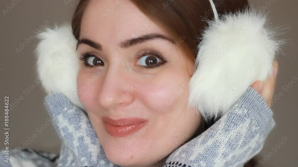 Portrait of a young beautiful woman close-up in warm winter headphones, which shows different emotions. Lovely girl smiles, laughs, expresses delight, joy and surprise Portrait of a young beautiful woman close-up in warm winter headphones, which shows different emotions. Lovely girl smiles, laughs, expresses delight, joy and surprise