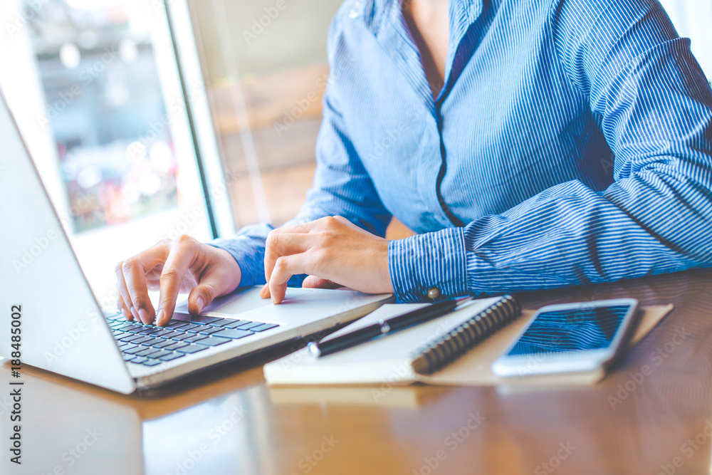 Business woman hand working with a laptop computer in the office.