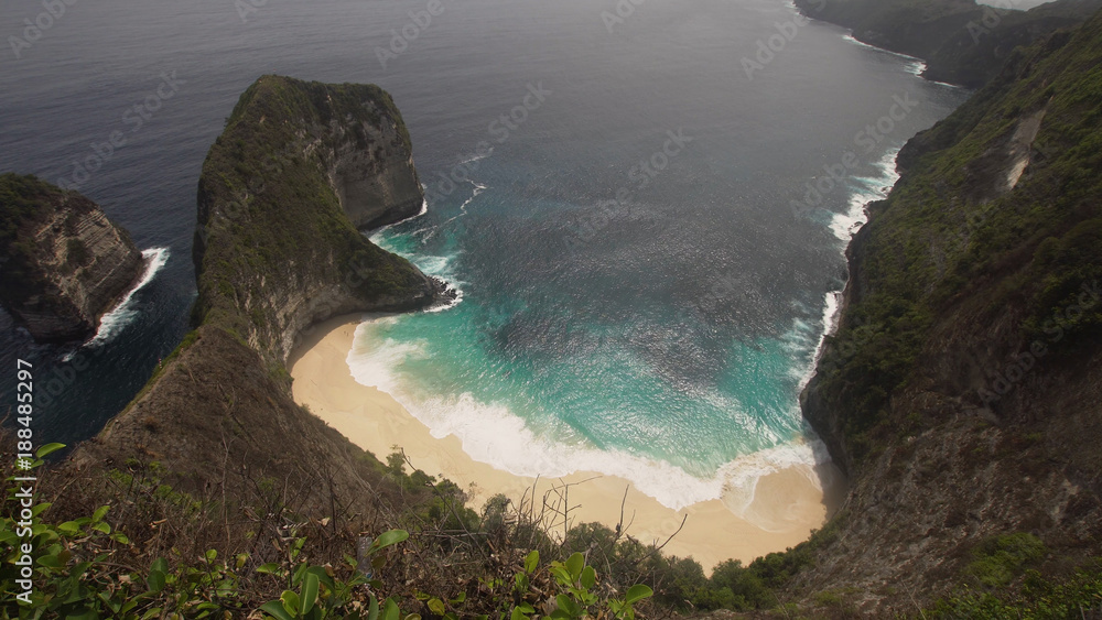 Beach with turquoise water among the rocks. Tropical beach among rocky cliffs. Karang Dawa, Manta Bay or Kelingking Beach on Nusa Penida Island, Bali, Indonesia.Travel concept. - obrazy, fototapety, plakaty 