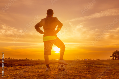 Fototapeta Naklejka Na Ścianę i Meble -  silhouette football player at sunset or sunrise background