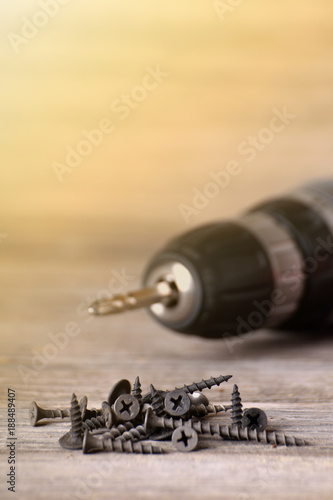Close up Electric drill on wooden table background and copy space. Hammer drill or screwdriver, Electric cordless hand drill on wooden. maintenance home concept. Screwdriver on a wooden background wi