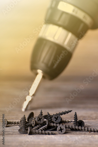 Close up Electric drill on wooden table background and copy space. Hammer drill or screwdriver, Electric cordless hand drill on wooden. maintenance home concept. Screwdriver on a wooden background wi