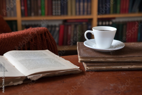 Sweet moments of relaxation with books and a cup of coffee. Vintage books, glasses, chair, library