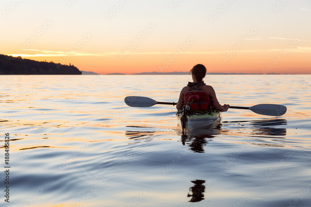 Girl Kayaking on a Sea Kayak during colorful and vibrant Sunset. Taken near Jericho Beach, Vancouver, British Columbia, Canada.