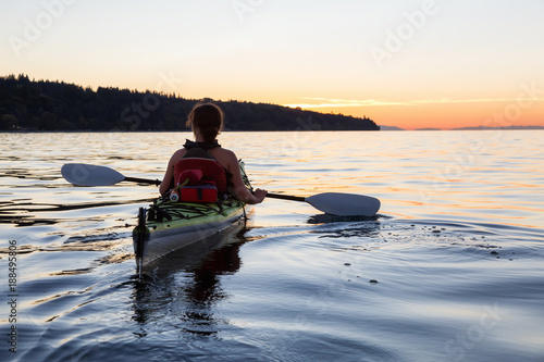 Girl Kayaking on a Sea Kayak during colorful and vibrant Sunset. Taken near Jericho Beach, Vancouver, British Columbia, Canada.