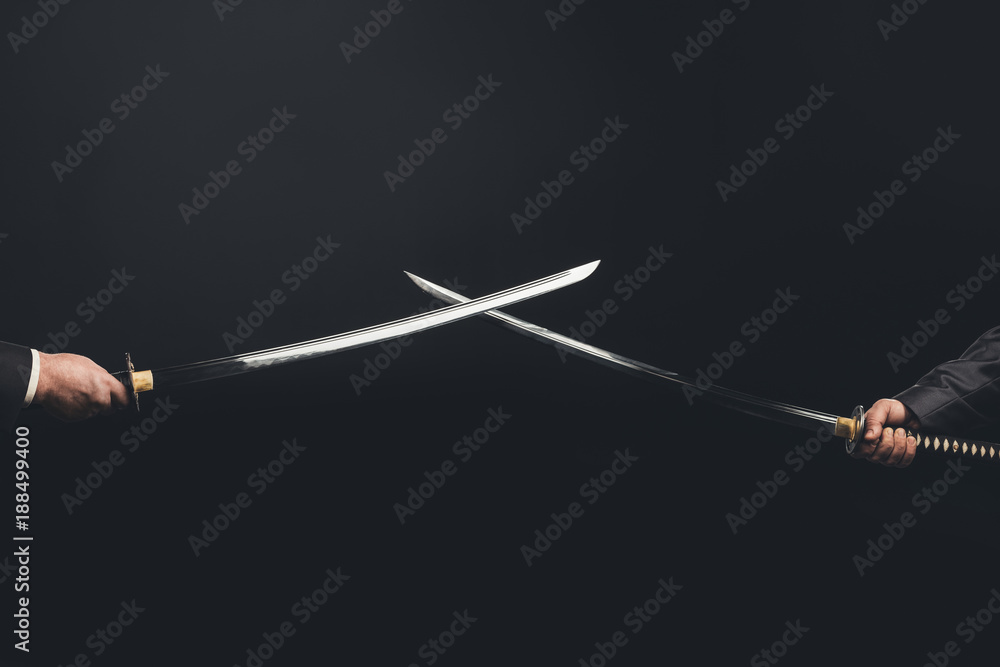 Fototapeta premium Cropped shot of samurai with crossed swords isolated on black