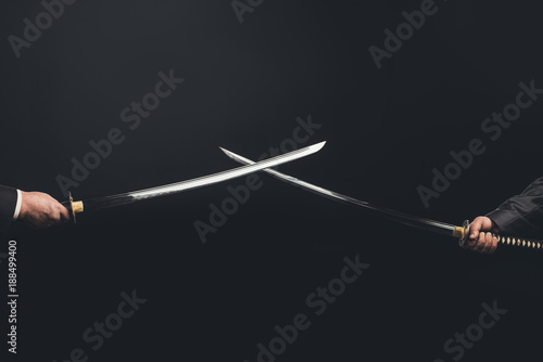 Cropped shot of samurai with crossed swords isolated on black